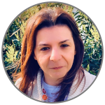 Cinzia Cantacessi, smiling, in front of a hedge background 